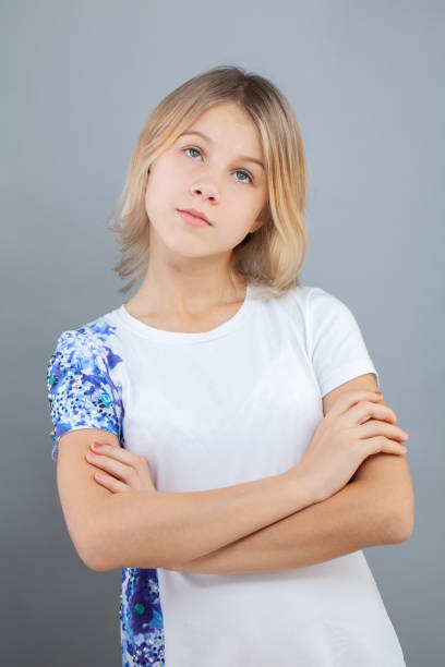 istock Cute pensive young girl thinking and looking up on gray background 1401958178