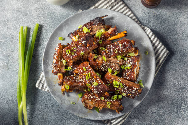 Homemade Spicy Asian Baby Back Ribs Homemade Spicy Asian Baby Back Ribs with Sesame and Green Onions braised stock pictures, royalty-free photos & images