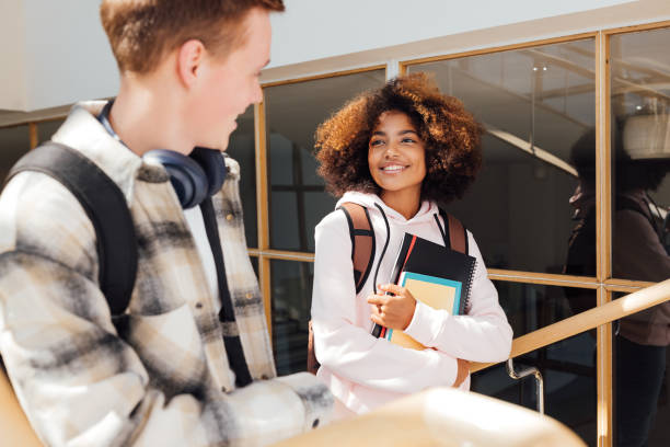 istock Two classmates looking at each other while climbing college stairs 1401960978