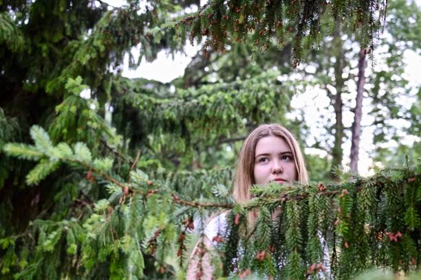 Cute beautiful girl smiling while tree is covering her face