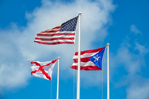 American, Puerto Rican and Spanish Empire Flags in San Juan, Puerto Rico on a sunny day.