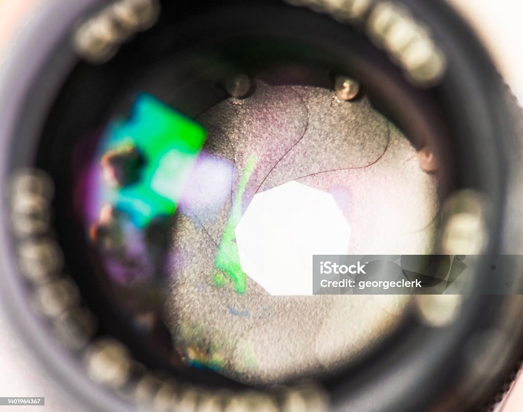 Cinematography - camera lens close-up Close-up looking through the glass of a camera lens, with the variable aperture visible. Camera - Photographic Equipment Stock Photo