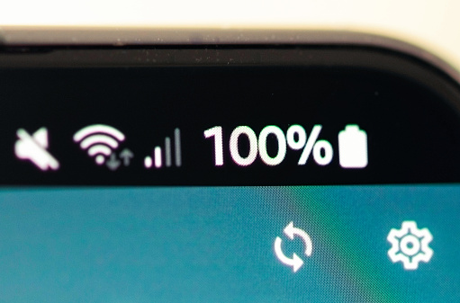 Icons at the top of a smartphone's screen showing that the battery is fully charged, along with cellphone radio strength, wifi signal strength and volume settings on mute.