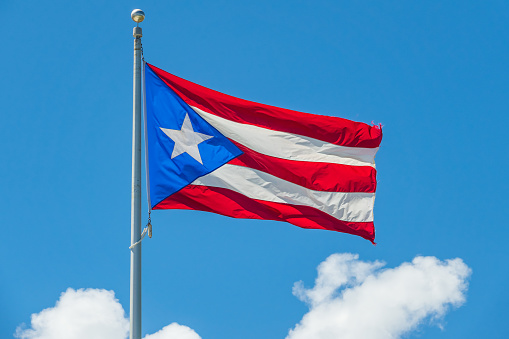 Close-up view of the Cuba national flag waving in the wind. The Republic of Cuba is an island state in Central America. Fabric textured background. Selective focus.