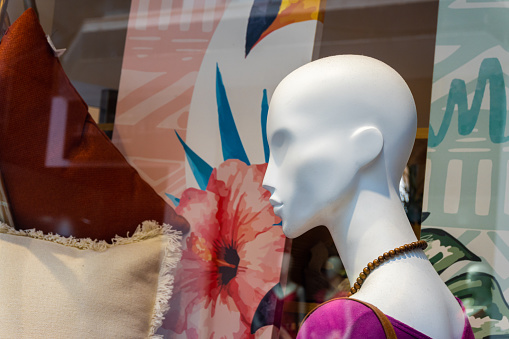 Close-up of the head of a mannequin without expressions, inside the window of a fashion store