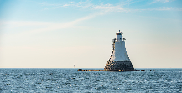 Lighthouse of Viten in Gothenburg archipelago. Sailboat in the horizon.