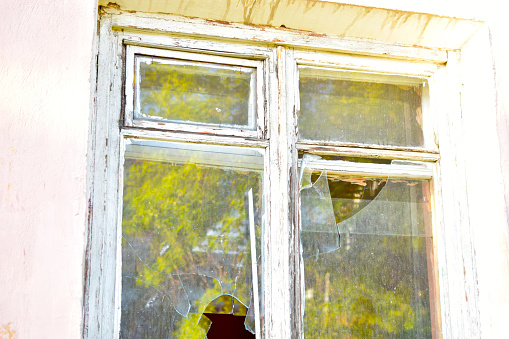 Two broken window panes of an abandoned industrial building.