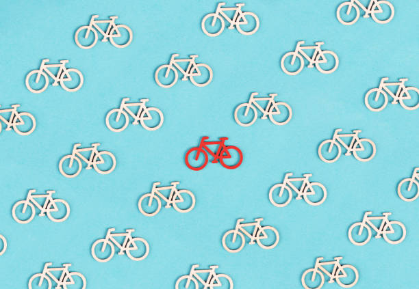 Many small bicycles, one red is standing out, leadership concept, think different, minimalistic lifestyle, alternative transportation, environmetal issue