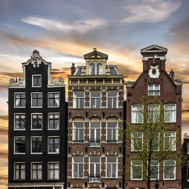 historical town houses in amsterdam, netherlands. sunset view - grachtenpand stockfoto's en -beelden