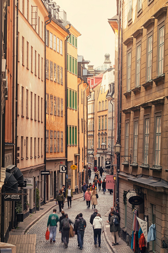 Tourists walking down Österlånggatan street in Gamla Stan (the old town) of Stockholm.