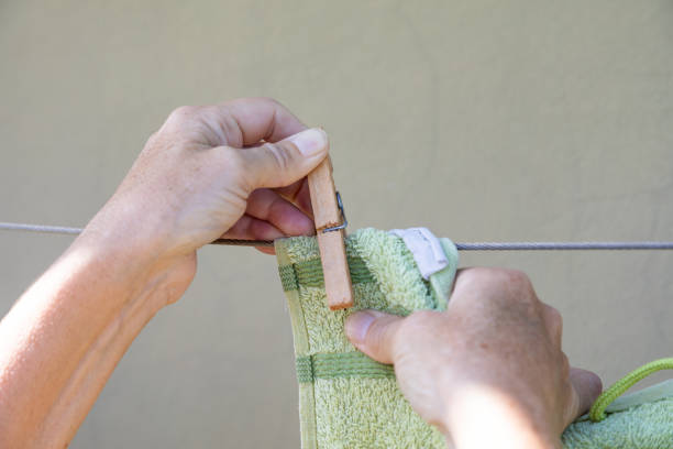 istock Close-up of woman's hands hanging up washed clothes. 1401976495
