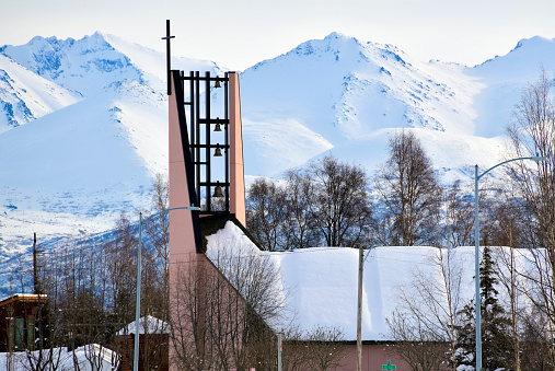 Anchorage, Alaska, USA: First Presbyterian Church on West 10th Avenue, winter landscape with the Chugach Mountains.