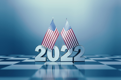 American flag pair and 2022 on a chess board. Horizontal composition with copy space and selective focus. 2022 Midterm Elections concept.
