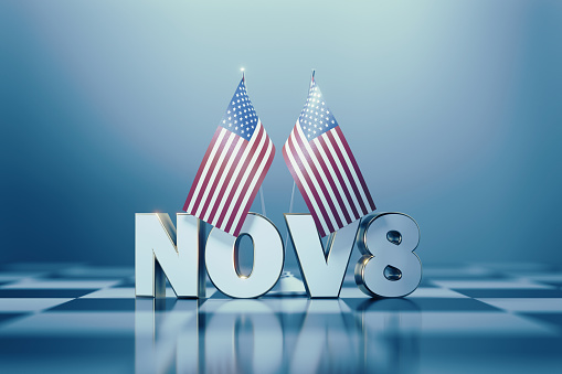 American flag pair and November 8 on a chess board. Horizontal composition with copy space and selective focus. 2022 Midterm Elections concept.