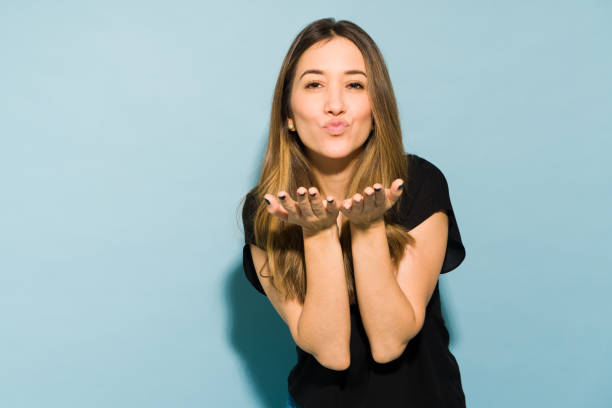 istock Good looking Caucasian brunette blowing a kiss in a studio 1401980458
