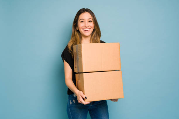 Happy woman just received a few packages from her online purchases in a studio stock photo