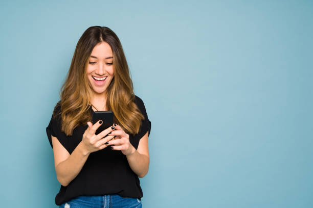 istock Excited young woman looking at her smartphone in a studio 1401980782