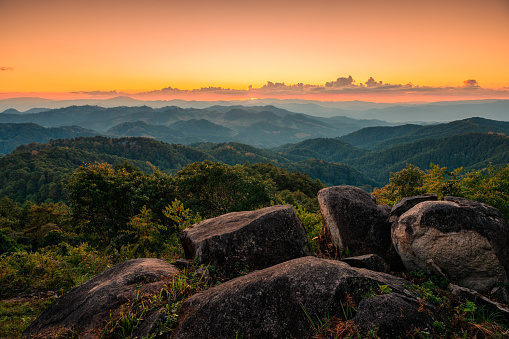 Colorful sunset over mountain range in tropical rainforest and rocks at national park. Doi Kham Fah, Wiang Haeng, Chiang Mai, Thailand