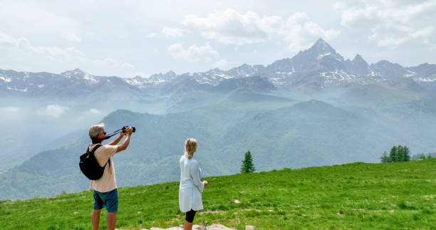 istock Mature couple relax in meadow, taking photos 1401986169