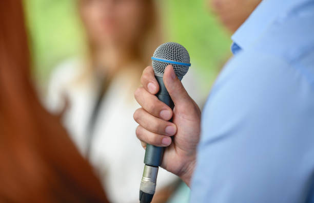 istock Man from the audience holding a microphone 1401986594