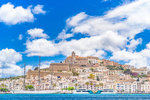 An extremely detailed view of Eivissa's old town centre and marina, bright sky, picturesque clouds, a moored sailing ship, the iconic skyline of Dalt Vila dominated by the cathedral church of Santa Maria de les Neus. Developed from RAW.