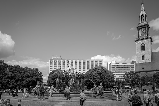 many people cavort at the famous Neptun fountain in Berlin in Black and white