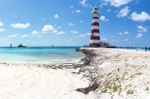 Red and white ringed Lighthouse on Caribbean beach in the Bahamas