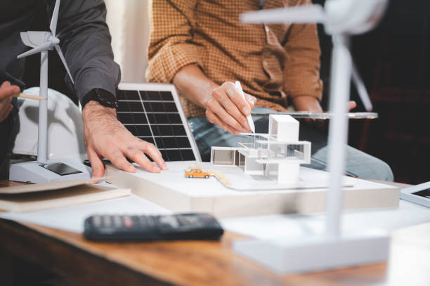 istock Two engineer design professionals discussion about calculate to use pure energy nature and Installing solar panels on roof house to generate electricity working with model, and Solar panel sample 1401993113