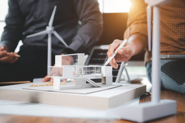 Two engineer design professionals discussion about calculate to use pure energy nature and Installing solar panels on roof house to generate electricity working with model, and Solar panel sample