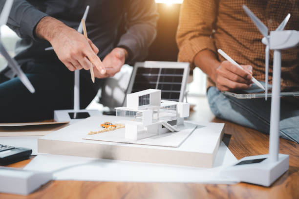 istock Two engineer design professionals discussion about calculate to use pure energy nature and Installing solar panels on roof house to generate electricity working with model, and Solar panel sample 1401993135