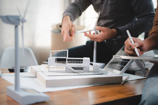 istock Two engineer design professionals discussion about calculate to use pure energy nature and Installing solar panels on roof house to generate electricity working with model, and Solar panel sample 1401993141