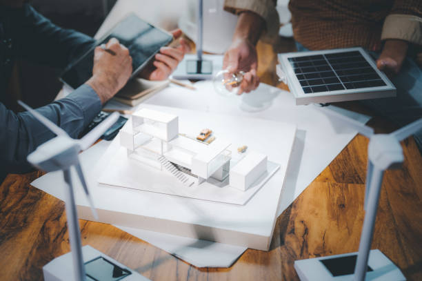 istock Energy engineer professionals discussion about calculating to use pure energy nature and Installing solar panels on roof house to generate electricity working with model, and Solar panel sample 1401993164