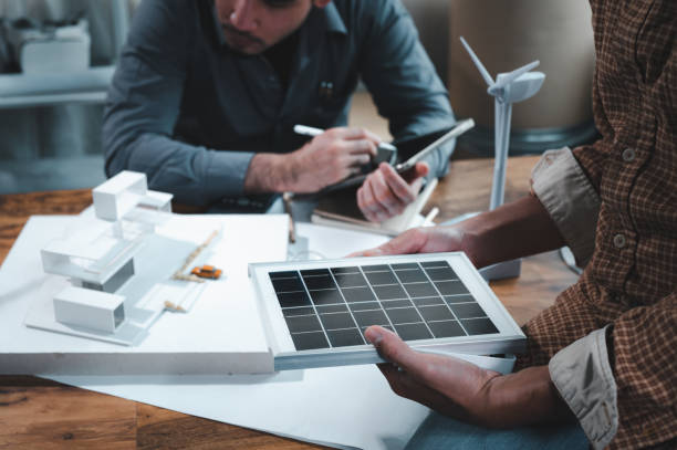 istock Energy engineer professionals discussion about calculating to use pure energy nature and Installing solar panels on roof house to generate electricity working with model, and Solar panel sample 1401993172
