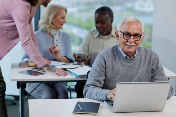 istock A senior woman is smiling while having a retraining class with a multicultural group of senior people in the classroom. 1401995215