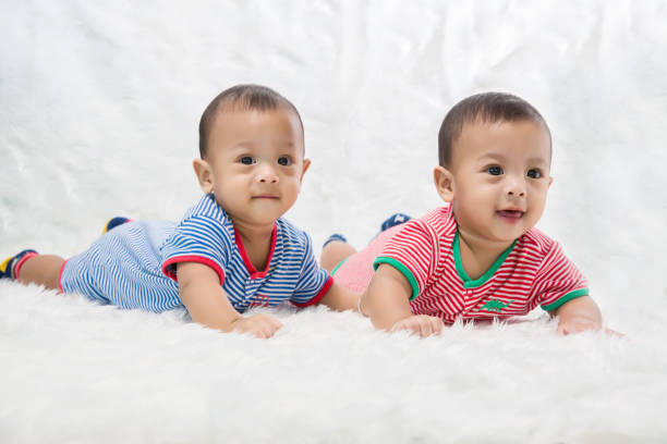 bambino che dorme sul tappeto. i neonati dormono a letto. bel sonno dei neonati sul letto. il bambino carino sta girando in studio. immagine di moda del bambino e della famiglia. - twin newborn baby baby girls foto e immagini stock