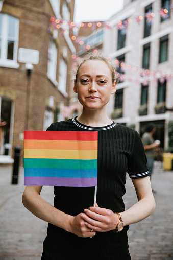 LGBT proud. Happy woman holding lgbt flag