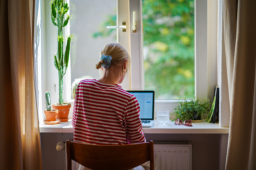 Young woman working from home in a bright cozy room