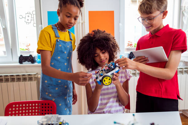 A group of cheerful tweens in a classroom, making robots for a school competition