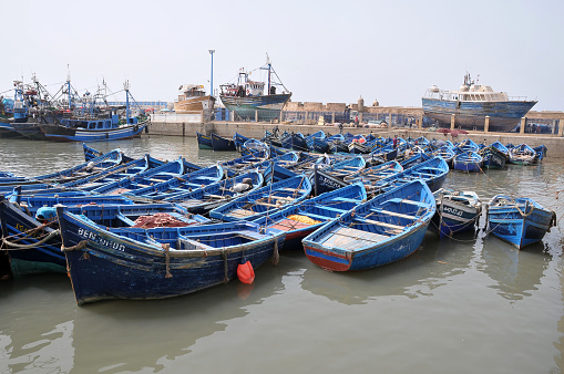 Essaouira, Morocco - March 24, 2012: Typical fishing boats painted blue, anchored in the city's fishing port