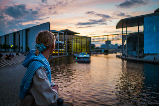 A woman enjoying the view of the Government District in Berlin at sunset