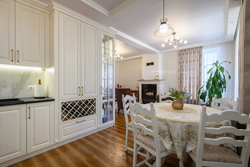 Modern classic large white colored luxurious kitchen and dining room in studio apartment interior