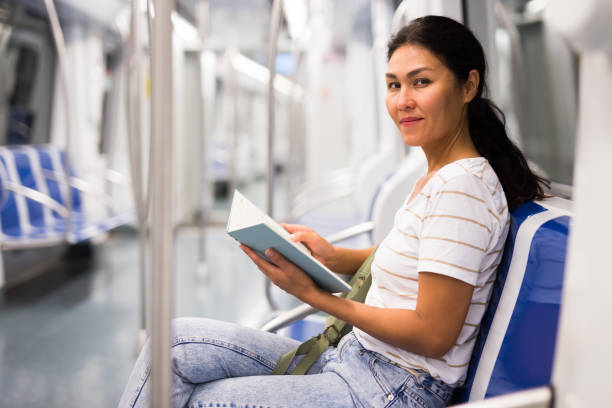 istock Oriental woman with book in metropolitan train 1402001271
