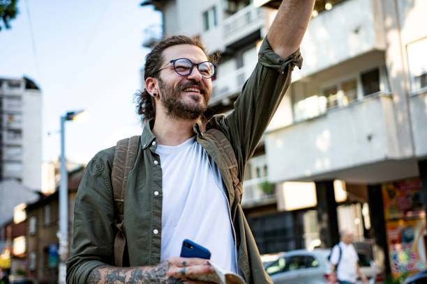 istock Modern young man walking on the street looking happy 1402002347