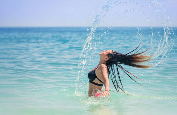 istock Beautiful young girl having fun at the beach 1402002680