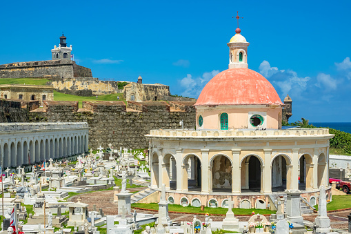 Santa Maria Magdalena de Pazzis Cemetery, a colonial-era cemetery, in Old San Juan, Puerto Rico on a sunny day, with El Morro Castle in the background.