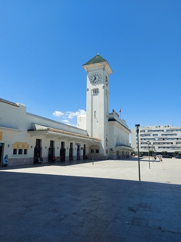 Side view of the old building with a clock tower of the old Casavoyageur train station entrance gates in Casablanca, Morocco.