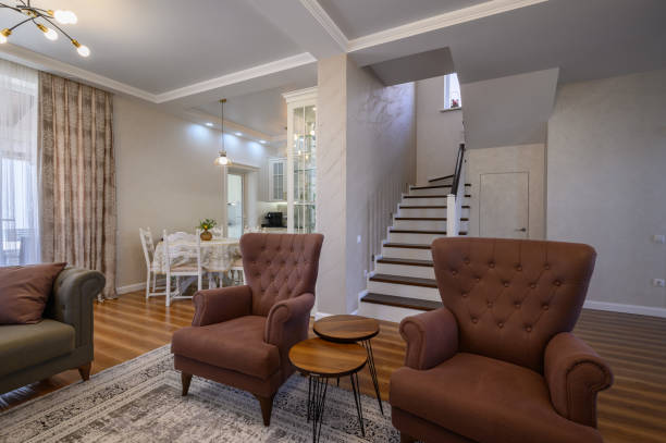 Modern architecture interior with luxury hallway with glossy wooden stairs in multi-storey house. Custom built pullout cabinets on glides in slots under stairs. Use of space for storage.