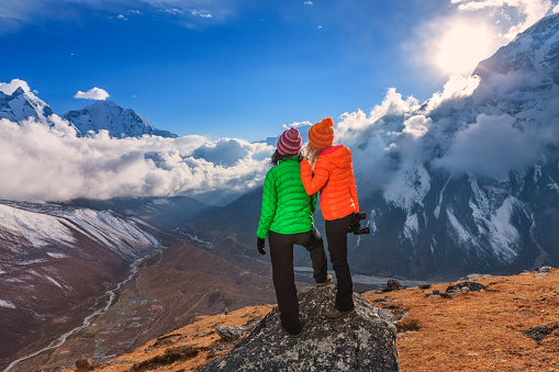 Two young women standing on the top of a mountain and watching sunset over Himalayas. Mount Everest National Park. This is the highest national park in the world, with the entire park located above 3,000 m ( 9,700 ft). This park includes three peaks higher than 8,000 m, including Mt Everest.