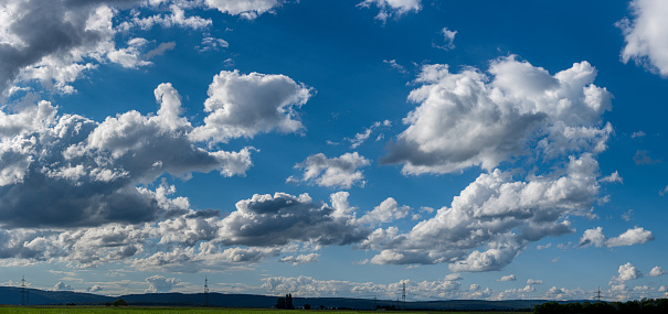 Panoramic view of fair-weather clouds with horizon at the bottom of the image and blue sky in sunny weather