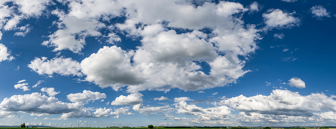Panoramic view of fair-weather clouds with horizon at the bottom of the image and blue sky in sunny weather